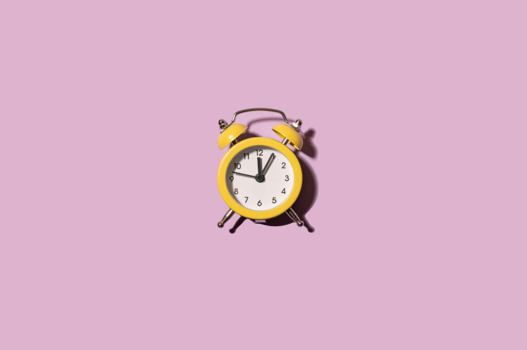 reloj-amarillo-sobre-fondo-morado